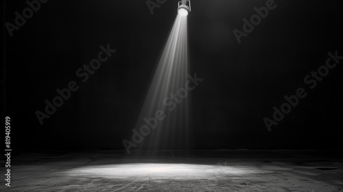 Black background illuminated by a single, powerful spotlight in the center