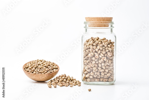 Glass jar and wooden spoon filled with raw buckwheat groats