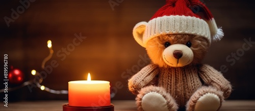 A soft toy bear with a knit cap beside a glowing flame