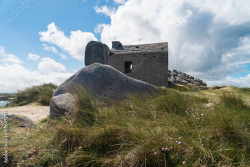 Un ancien corps de garde perché sur une colline, entourée de rochers imposants à Cléder, en Bretagne.