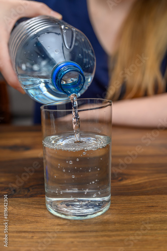 Zbliżenie na wodę nalewaną z butelki do szklanki
