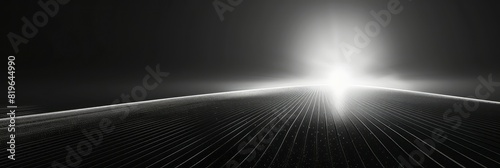 Monochrome image of a bright light shining at the distant end of a dark tunnel