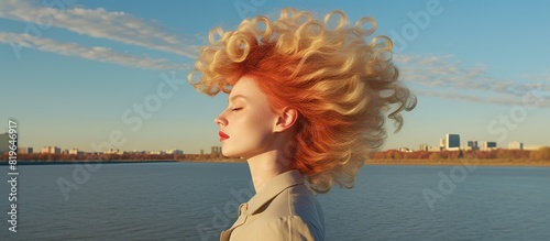 A woman from Volgograd posing by the Volga river with inflated lips and showcasing her gorgeous hair in a copy space image
