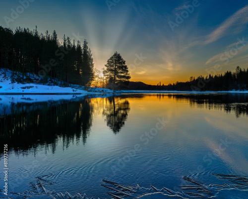 Serene lake illuminated by vibrant sunbeams at sunset