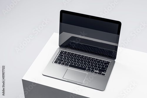Sophisticated laptop on a white podium with a dark screen, set in a minimalist environment, ideal for tech presentations. 3D Render