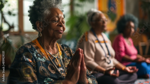 Senior black woman meditating together on wellness spa retreat. Retired elderly african american female pensioners practicing yoga meditation & deep breathing exercises for mental health & anxiety