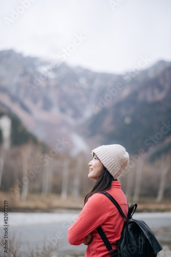 Solitary journey, Asian woman in a pink fleece climbing Japan's peak. Elegant portrait by the lake, capturing the success, happiness, and scenic freedom of an adventurous trip.