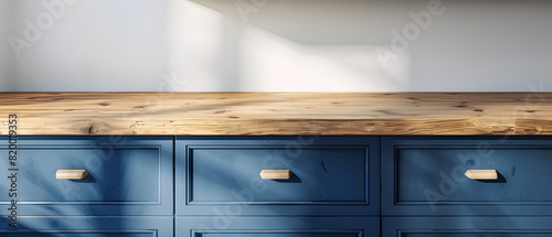 Close-up of blue kitchen cabinets and wooden countertop illuminated by natural sunlight