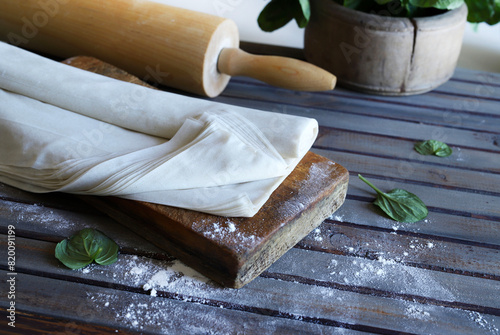 Pasta fillo cruda su un tavolo di legno rustico. Pasta filo sottile per cuocere al forno, per crostate e torte.