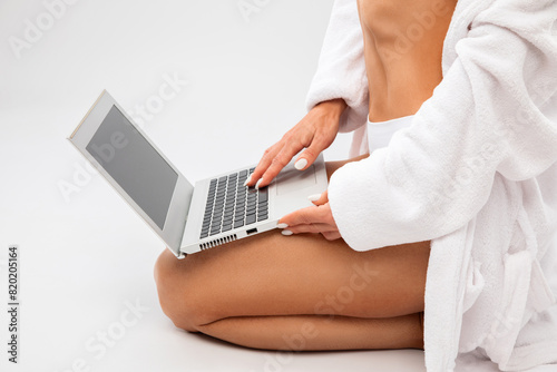 Slender dark-skinned woman blogger in white underwear and a dressing gown on a white background. Healthy lifestyle, sports and diet.