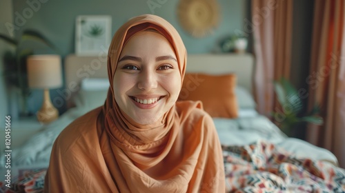 Close up view of the face of a Muslim woman wearing a hijab making a video call in the bedroom.