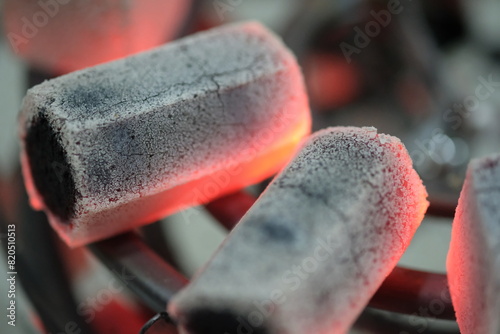 Briquettes on the stove. A briquette is a block of burnable material that is used as fuel to start and maintain a flame. Coconut shell charcoal briquettes, coal, peat, biomass.