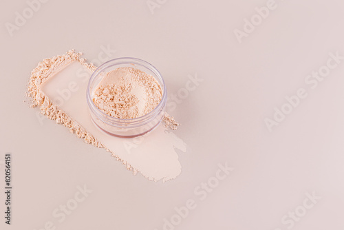 Open cosmetic jar with delicate loose powder on pastel background with powder swatch. A copy space. Product advertising.
