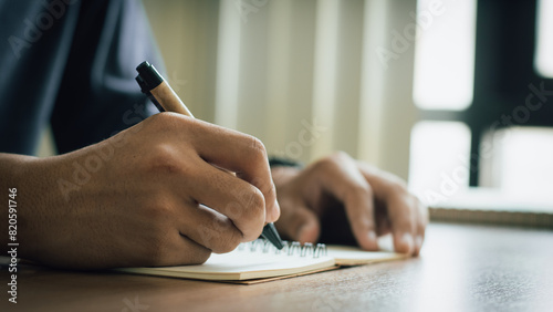 businessman working at work table,home office desk background, checklist writing planning investigate enthusiastic concept. Male hand taking notes on the notepad. 