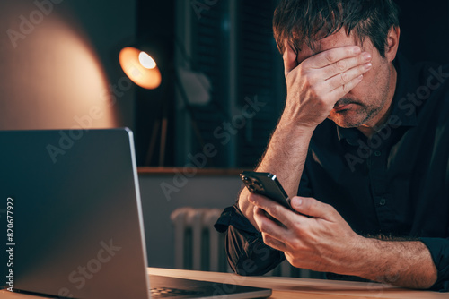 Sad unhappy disappointed freelancer reading worrying text message on smartphone