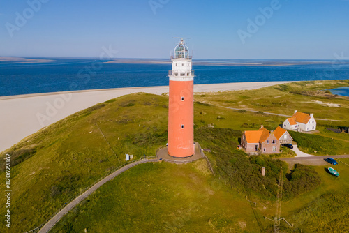Majestic lighthouse overlooking a sandy beach, standing tall and guiding ships with its bright light.