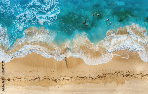 Aerial view of people walking along the beach, waves gently lapping at the shore, sandy beige texture with vibrant blue ocean water, tranquil and picturesque setting