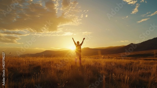 The girl on the top of the mountain raised both hands, the sun was setting. concept of success and achievement, joy, happiness.
