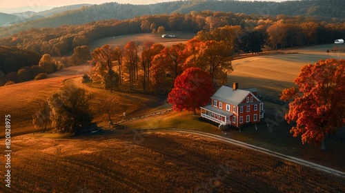 Autumn fall red color maple trees and farm house land rolling hills aerial above high angle view landscape in Blue Grass, Highland County, Virginia