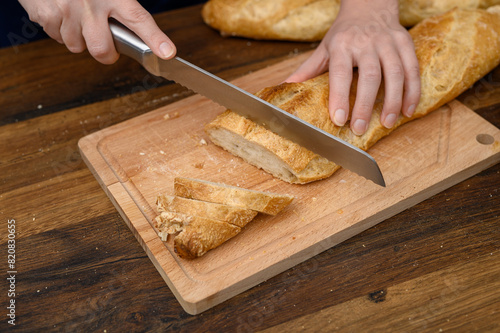 Kroić świeże bułki na śniadanie na desce do krojenia nożem do chleba