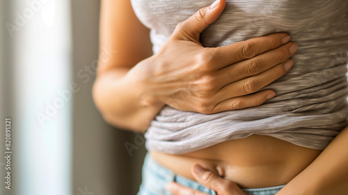 A young woman holding her stomach, abdominal pain, endometriosis, irritable bowel syndrome (IBS), ulcerative colitis, ectopic pregnancy, ovarian cysts, pelvic inflammatory disease (PID), gastro