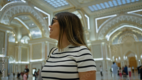 A young woman tours the ornate interior of abu dhabi's qasr al watan palace, reflecting the rich cultural heritage.