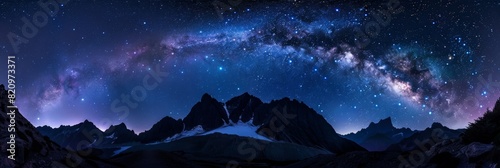 A breathtaking panorama of a star-filled sky over rugged mountain peaks.