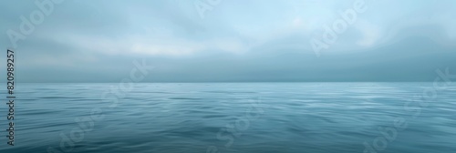 Foggy and misty ocean view with subtle waves under a heavy overcast sky.