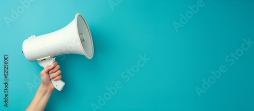 A woman's hand holds a white megaphone on a blue background. Concept of advertising, communication. Banner.