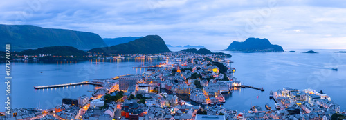 Panorama of Norwegian port town Alesund in evening time. Norway cityscape with fjord, islands, mountains, boats and typical norwegian houses