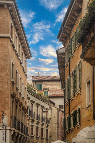 A view from inside on of the streets of Verona - Italy looking up at the sky with the facades of the buildings 