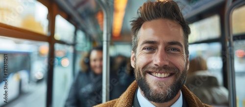 Smiling businessman with goatee stands in front of bus