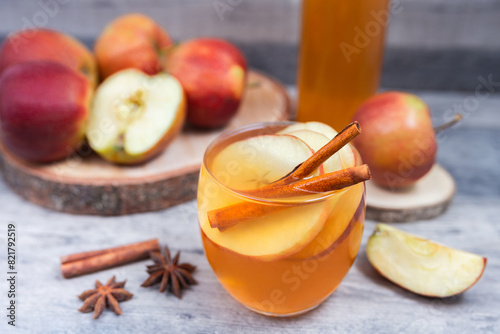 Hot mulled apple cider, juice with cinnamon and anise on wooden background. 