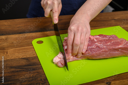 Kroić surowe mięso na kawałki, wieprzowina na desce do krojenia