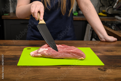 Kroić surowe mięso wieprzowe ostrym nożem w kuchni