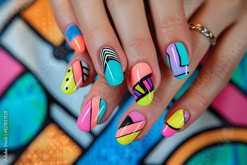close up manicure with abstract graphic colorful nail art design rounded nails on hands, on colorful painted colorblock background