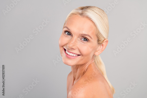 Photo of good mood pretty old woman naked shoulders smiling empty space isolated grey color background