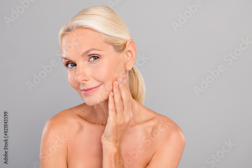 Portrait of charming aged woman use facial rejuvenate balm apply vitamins isolated on grey color background