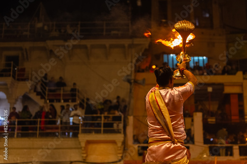 Ganga aarti, Portrait of young priest performing holy river ganges evening aarti at dashashwamedh ghat in traditional dress with hindu rituals.