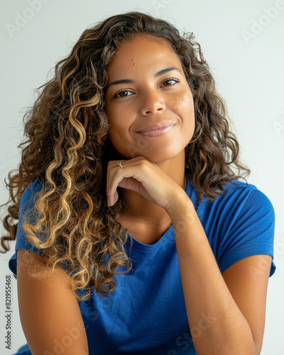 femme aux cheveux ondulés en t-shirt bleu, la tête appuyée sur sa main