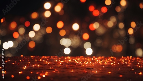 There are a lot of blurry orange lights in the background. There are also some white lights. The foreground is blurry, but it looks like there is a surface with a lot of tiny orange lights on it.