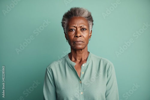 Mint background sad black American independent powerful Woman. Portrait of older mid-aged person beautiful bad mood expression girl Isolated