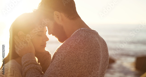 Couple, forehead kiss and hug on beach together for romantic sunset, bonding in nature and love, Happy, man and woman embrace on ocean sand for holiday, adventure and summer travel or vacation