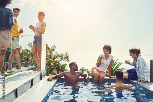 Friends, drinks and party in swimming pool with space for mock up with blue sky in summer with conversation. Men, women and people in group in water, relax and talking with alcohol at social event