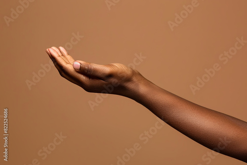 african american woman hand with palm facing upwards isolated on brown background