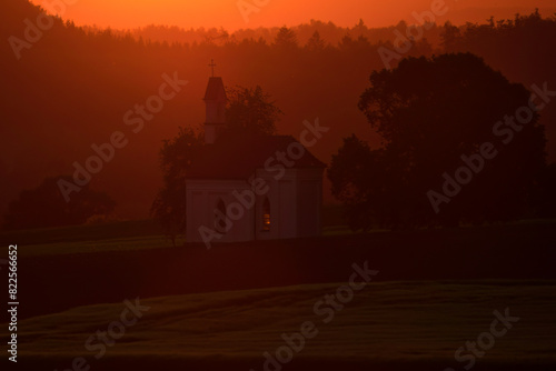 Aufnahme eines ländlichen Sonnenuntergangs mit einer Kapelle.