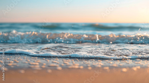 Gentle waves on sandy beach. Tranquil scene of ocean waves lapping on a sandy beach at sunset, perfect for travel and nature projects.
