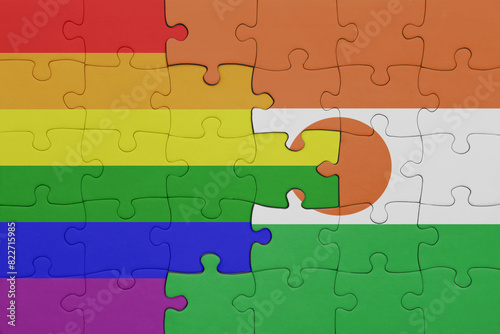 puzzle with the colourful national flag of niger and rainbow gay pride flag .