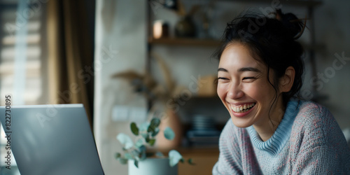 Happy young woman working remotely on virtual video team meeting call, remote work flexible culture concept, smiling asian female digital nomad freelancing on laptop at home, copy space