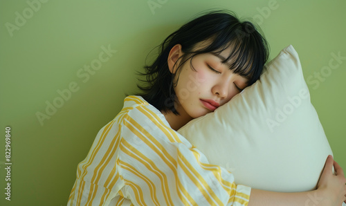 枕を持って寝ているパジャマ姿の女性